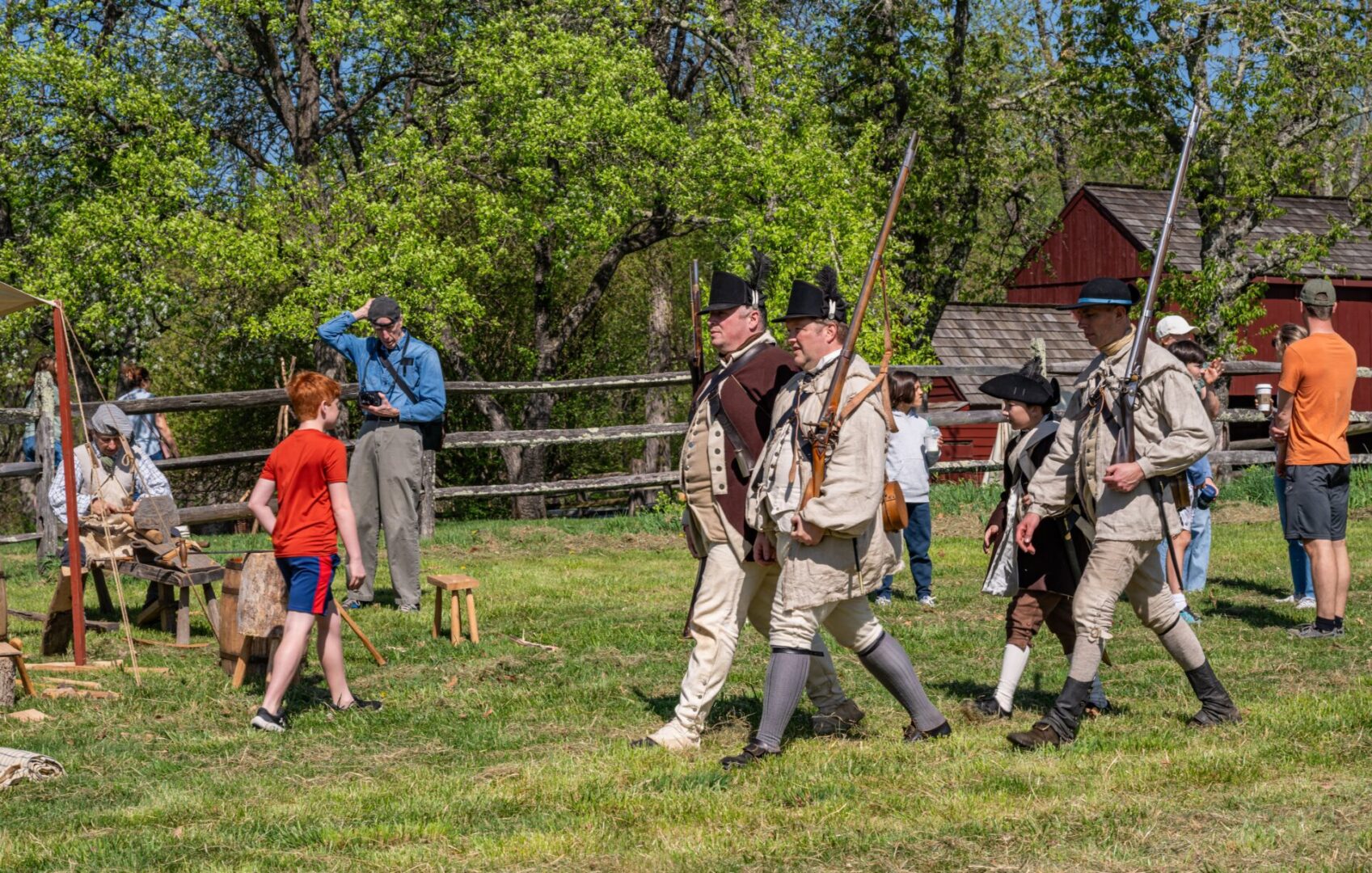 Colonial reenactors marching with muskets outdoors