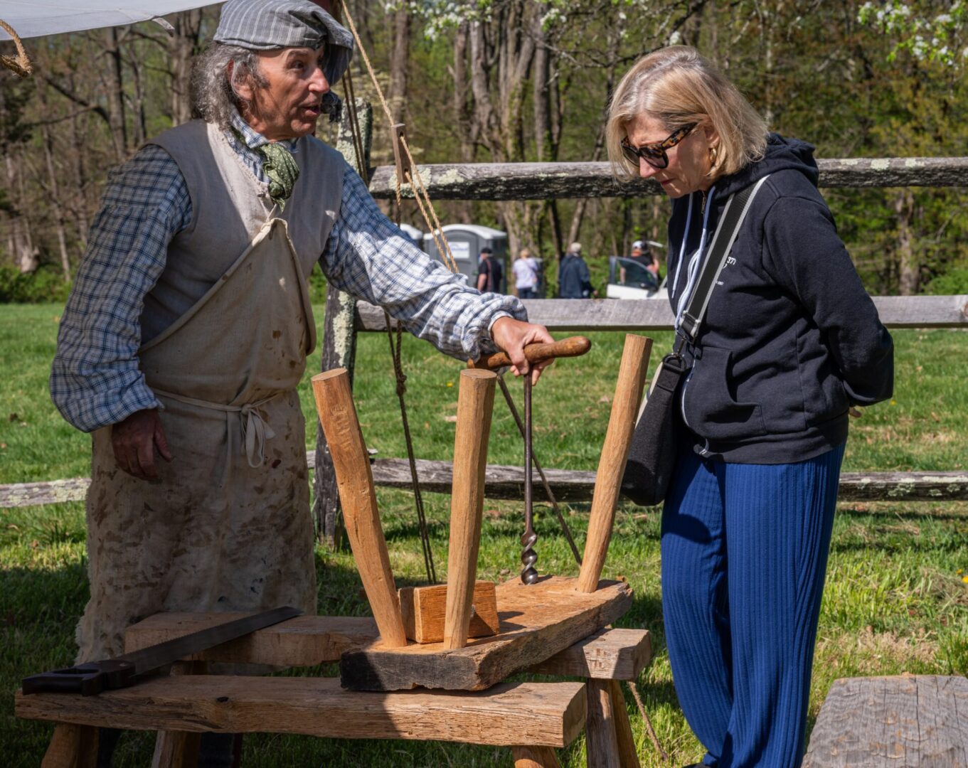 Craftsman demonstrating hand auger to visitor